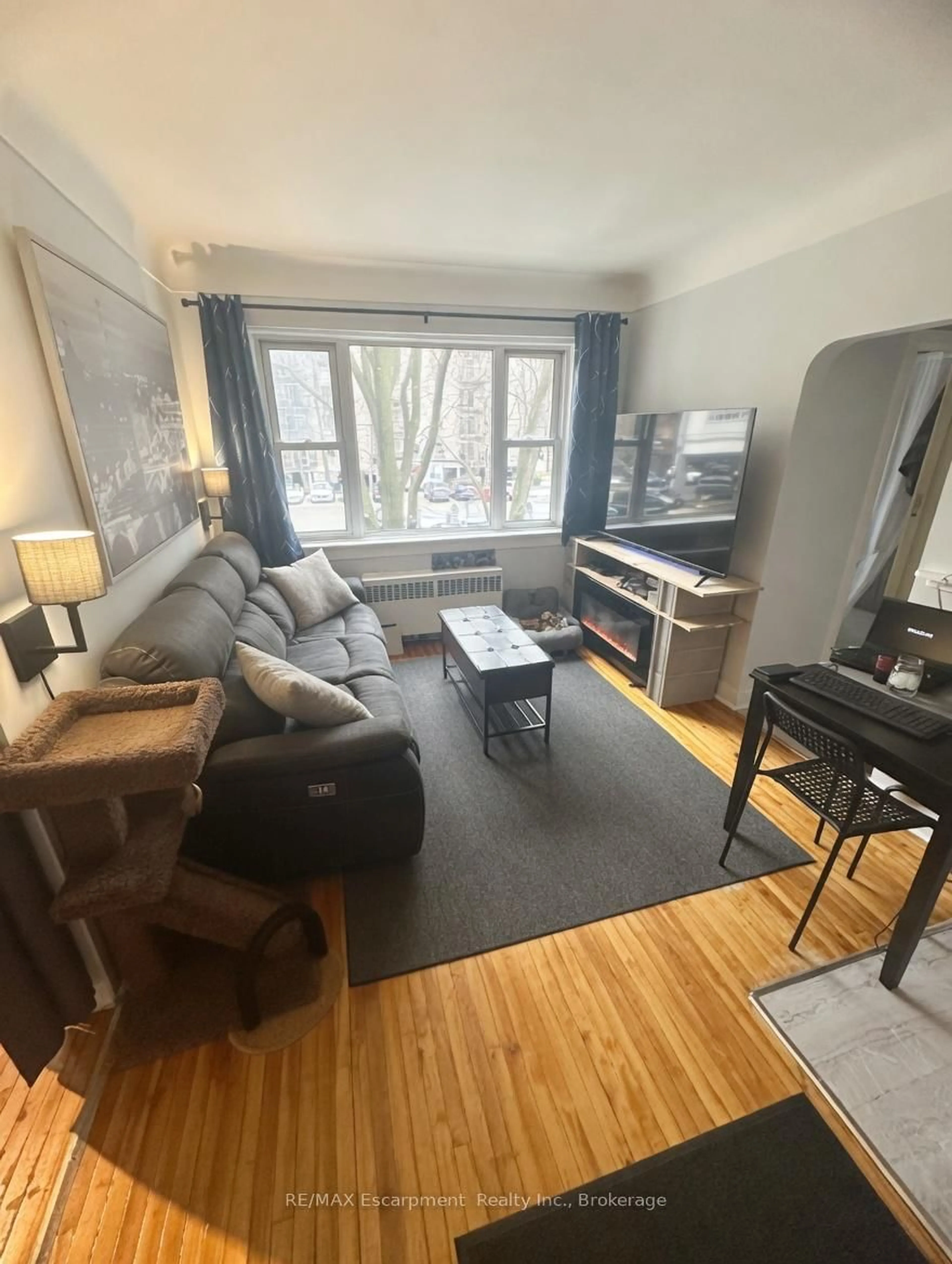 Living room with furniture, wood/laminate floor for 60 Robinson St #305, Hamilton Ontario L8P 1Y9