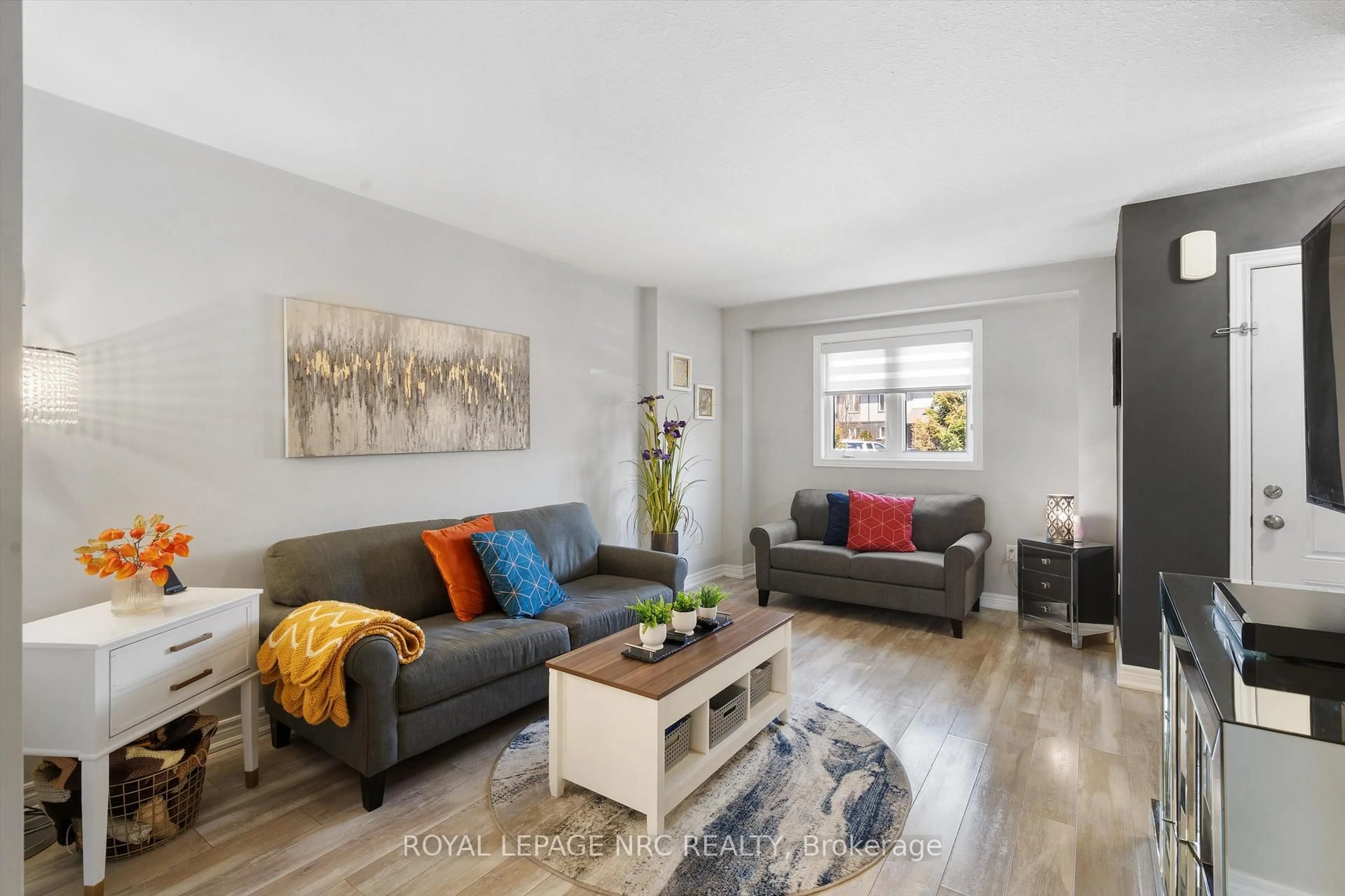 Living room with furniture, wood/laminate floor for 7768 Ascot Circ #20, Niagara Falls Ontario L2H 3P9