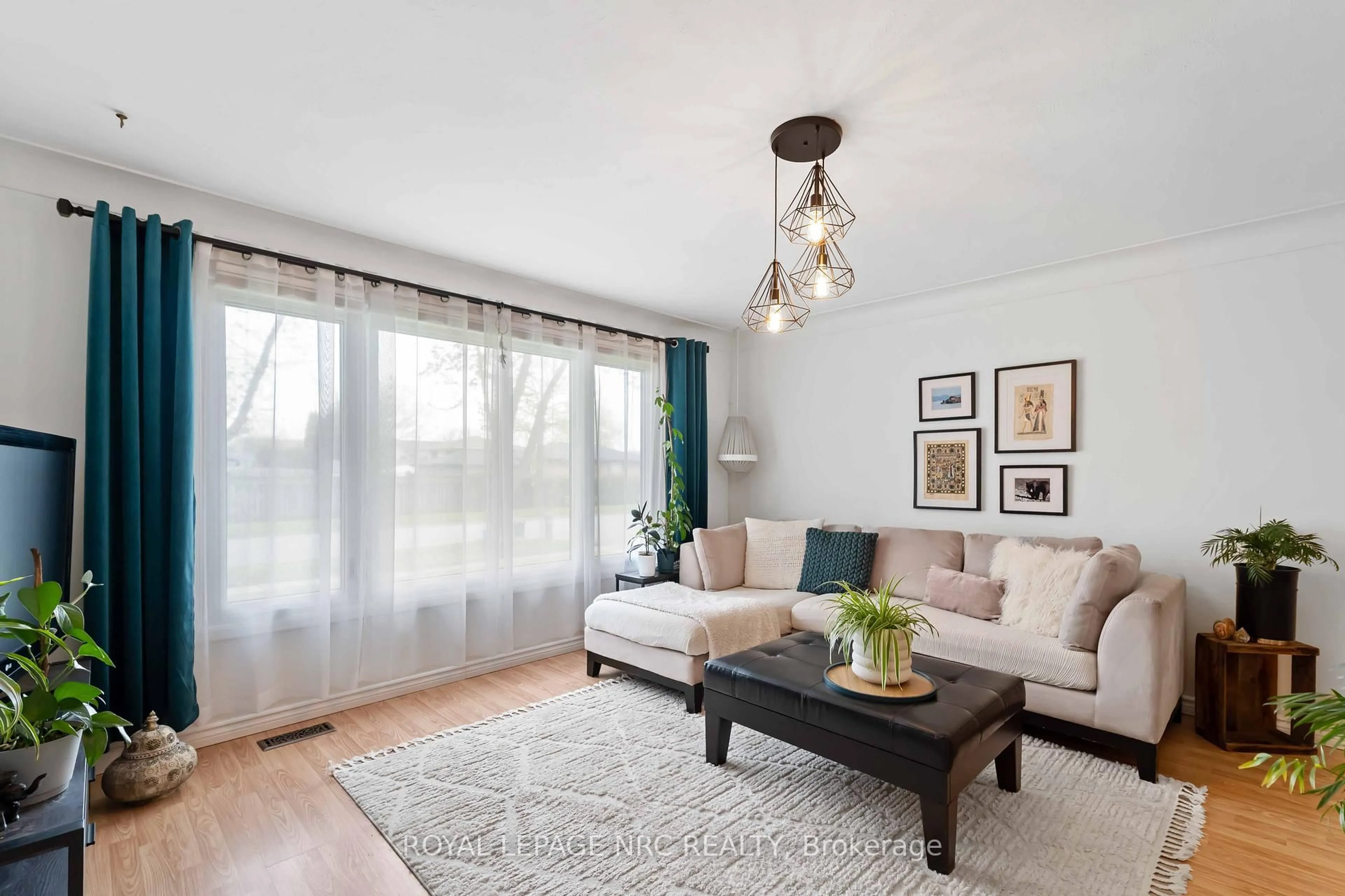 Living room with furniture, wood/laminate floor for 5753 Vine St, Niagara Falls Ontario L2J 1K8