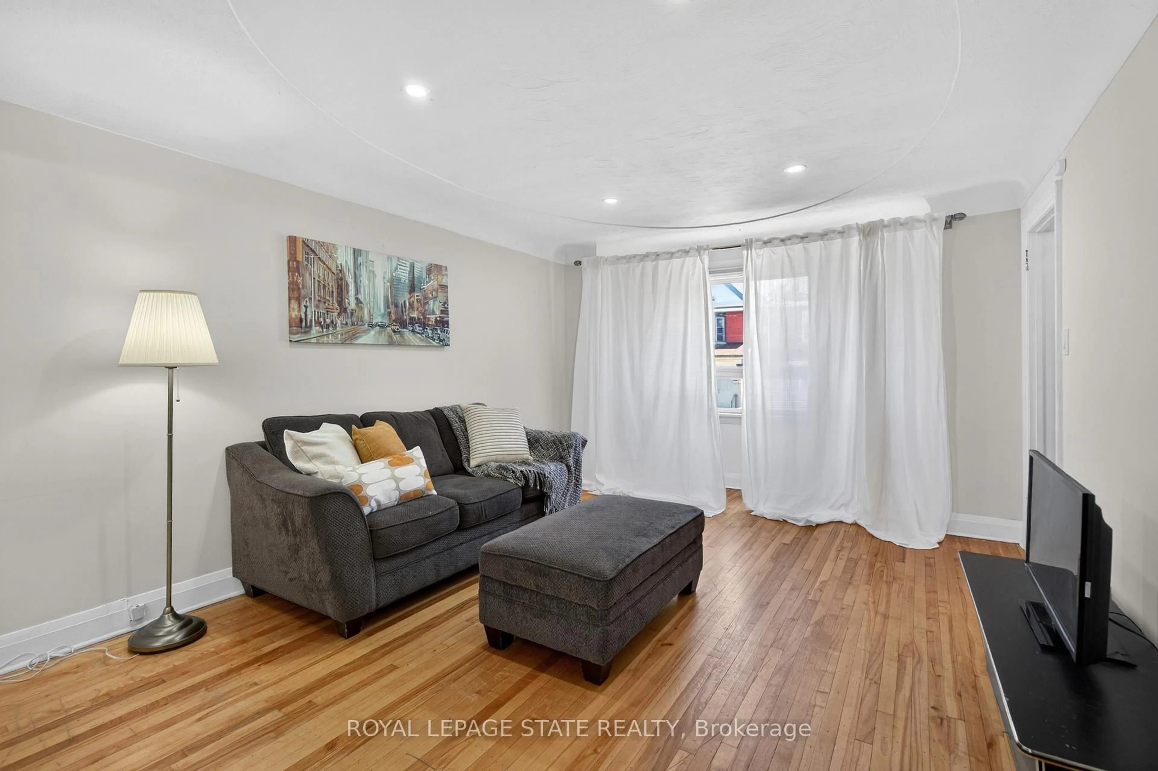 Living room with furniture, wood/laminate floor for 199 Stirton St, Hamilton Ontario L8L 6G7