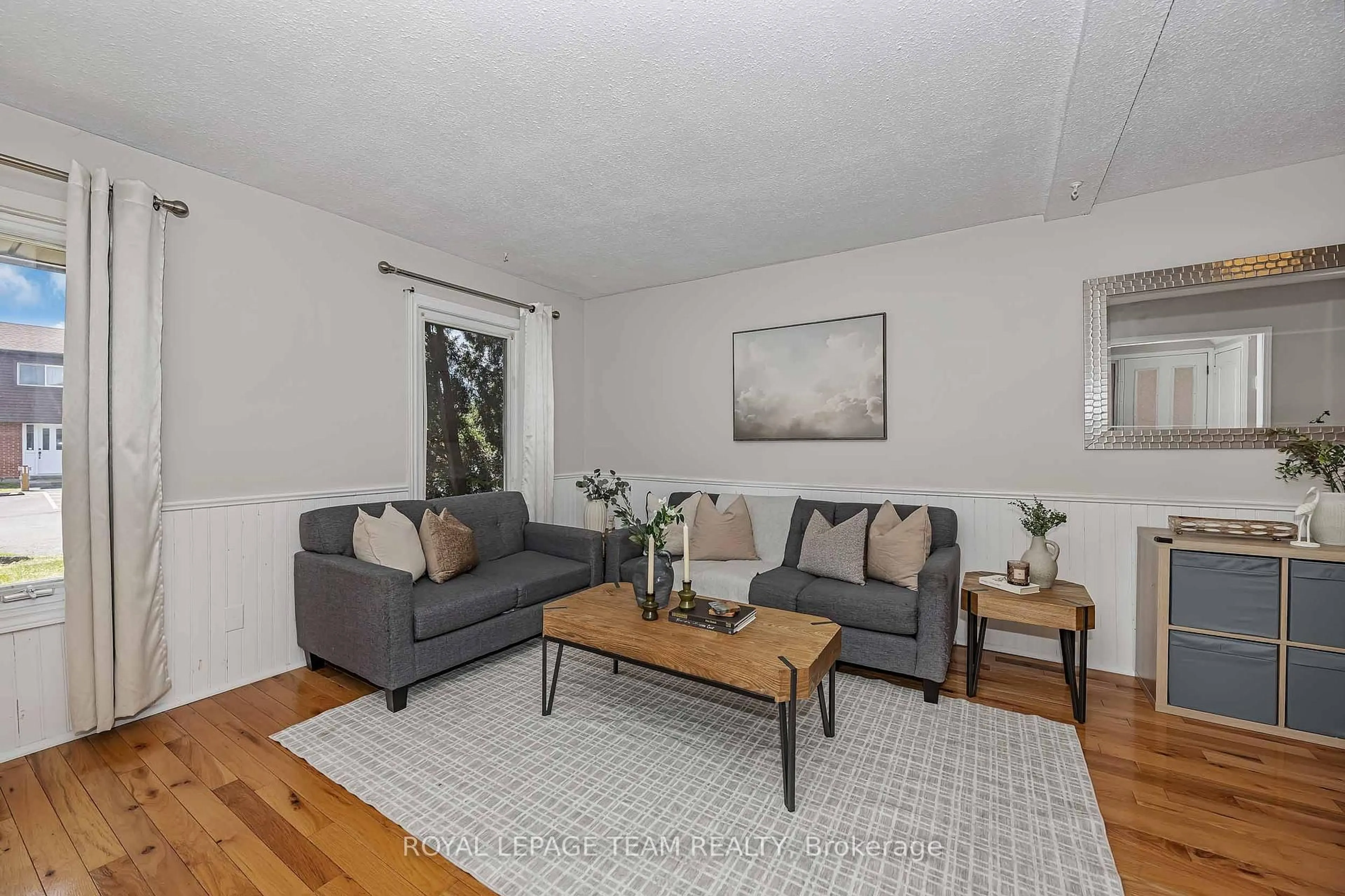 Living room with furniture, wood/laminate floor for 3107 Stockton Dr #26, Ottawa Ontario K1T 1S2