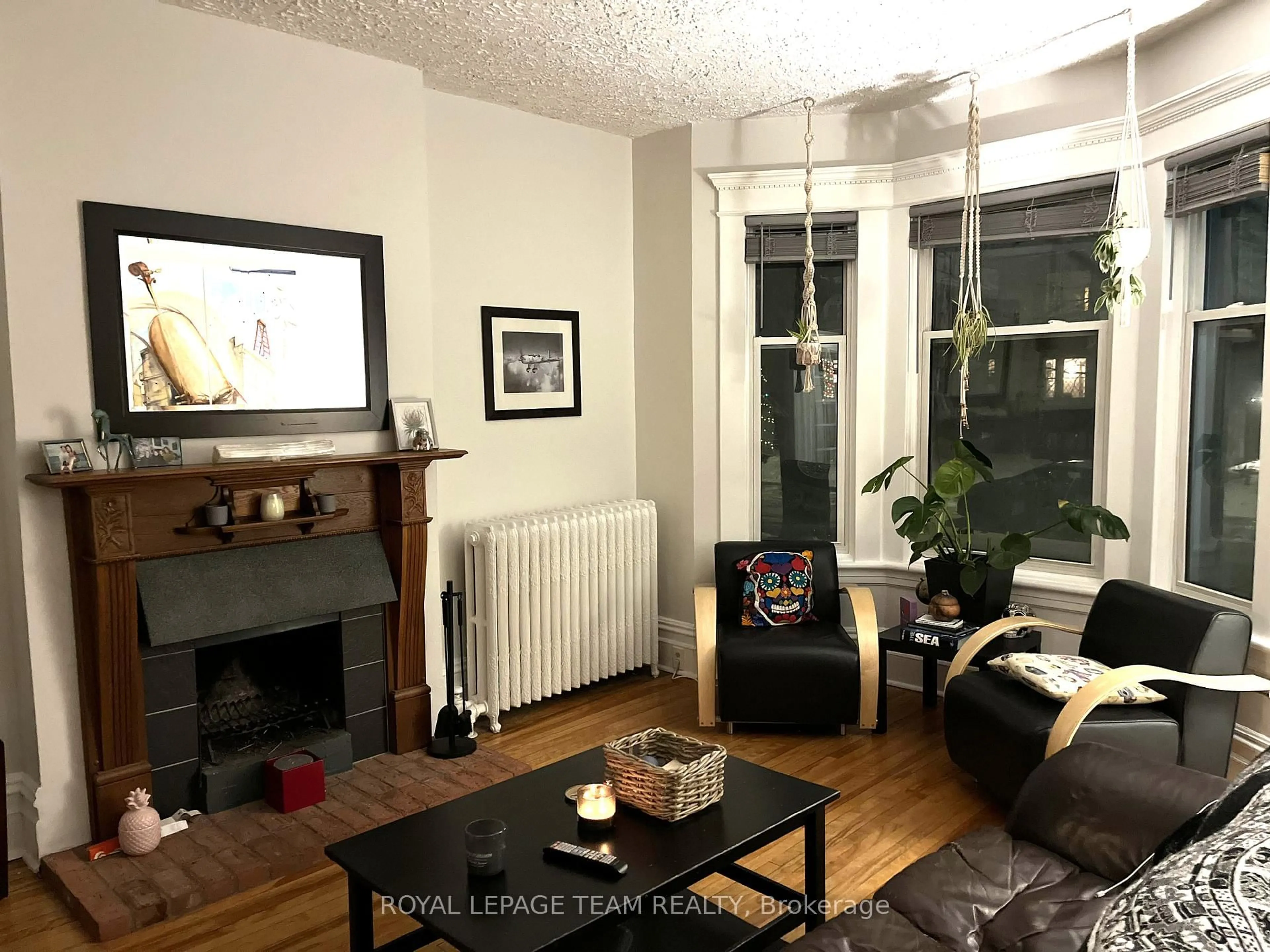 Living room with furniture, wood/laminate floor for 12 Woodlawn Ave, Ottawa Ontario K1S 2S9