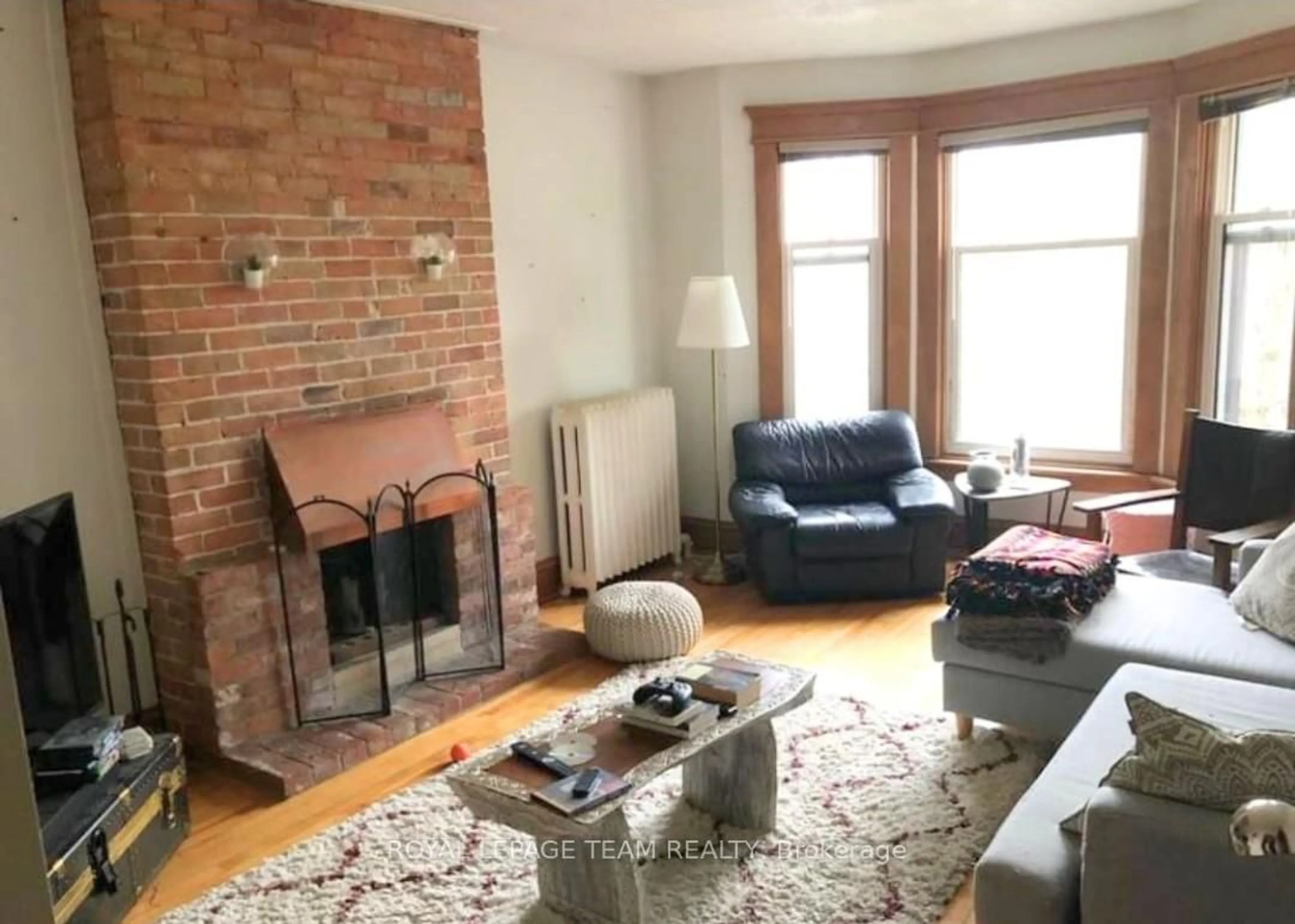 Living room with furniture, wood/laminate floor for 12 Woodlawn Ave, Ottawa Ontario K1S 2S9