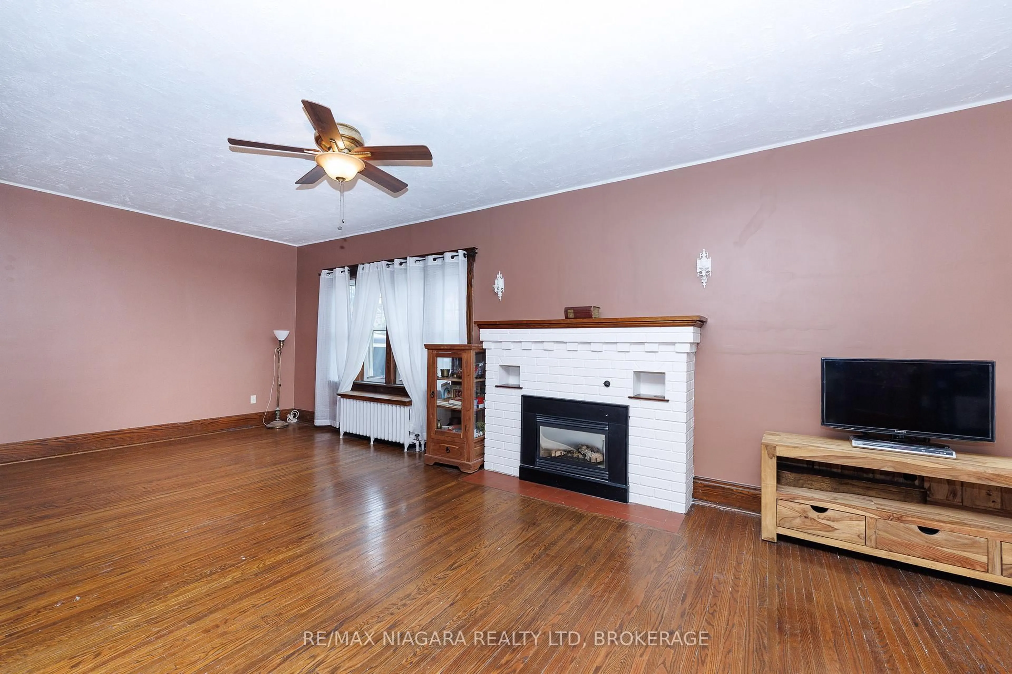 Living room with furniture, wood/laminate floor for 4864 Simcoe St, Niagara Falls Ontario L2E 1V9