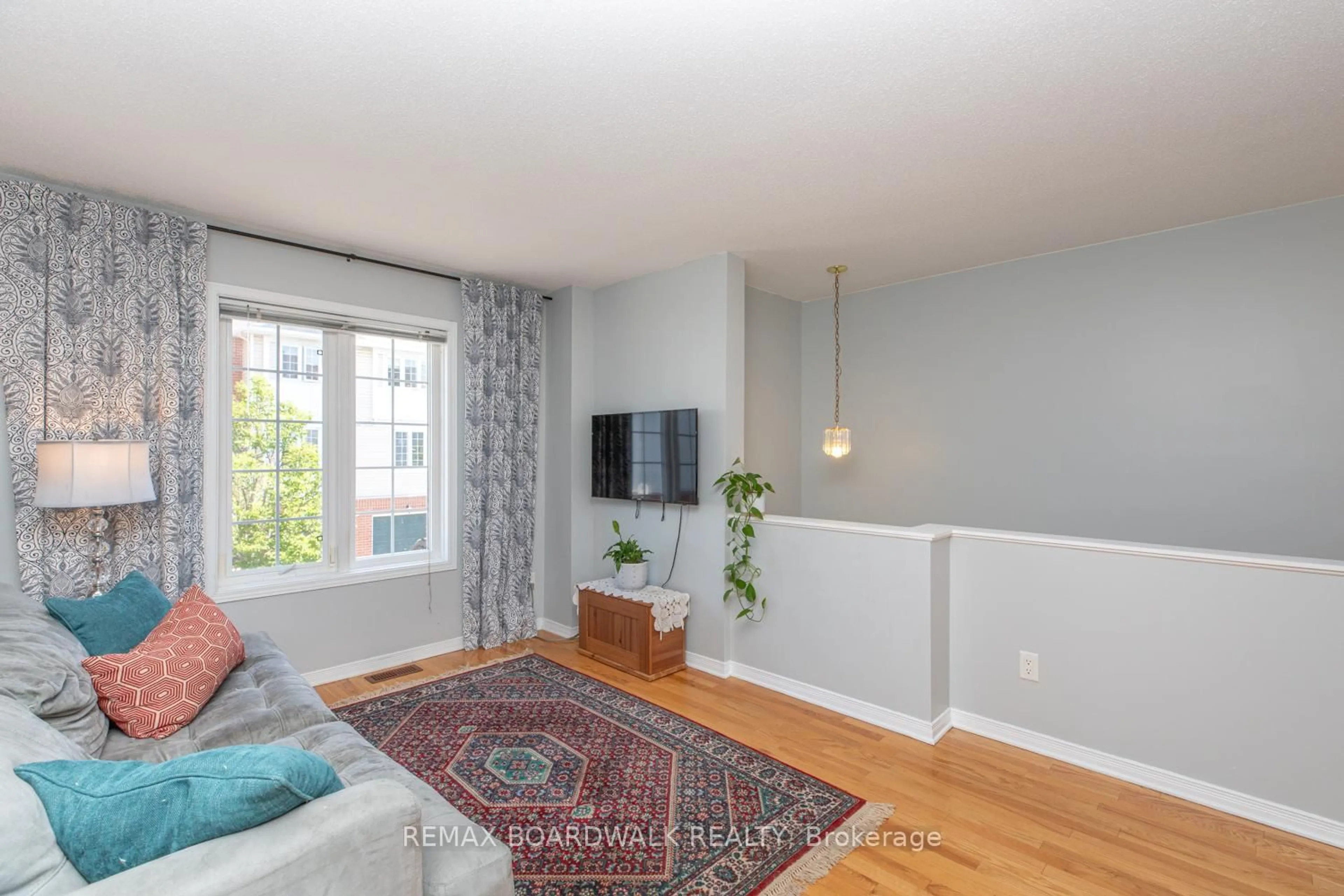 Living room with furniture, wood/laminate floor for 112 Wharhol Private, Ottawa Ontario K2H 1G6