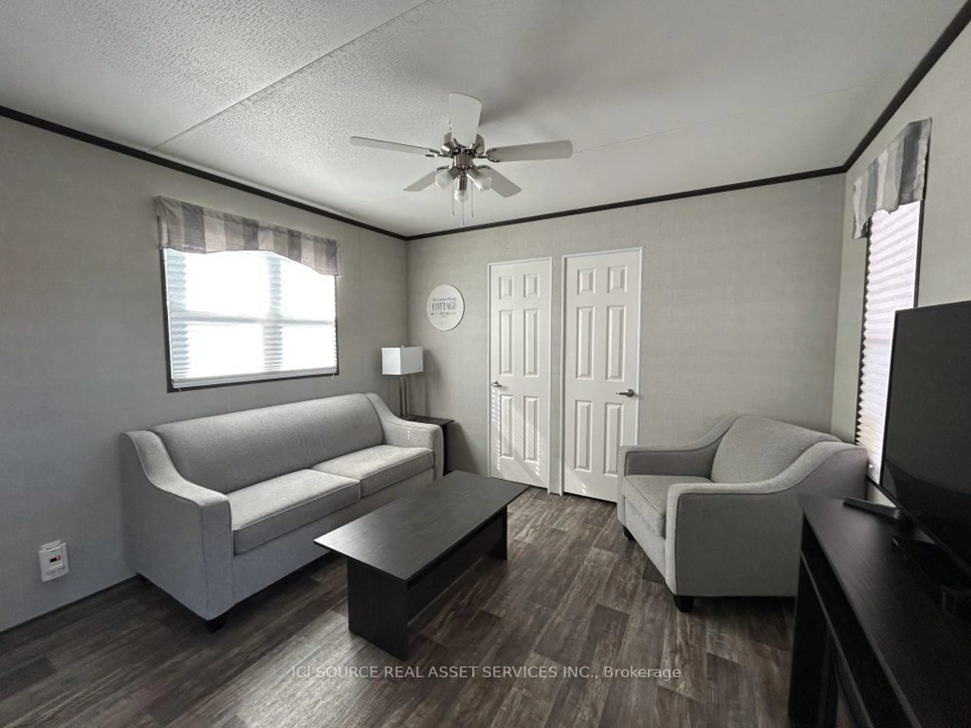 Living room with furniture, wood/laminate floor for 1235 Villiers Line #CHL027, Otonabee-South Monaghan Ontario K0L 2G0
