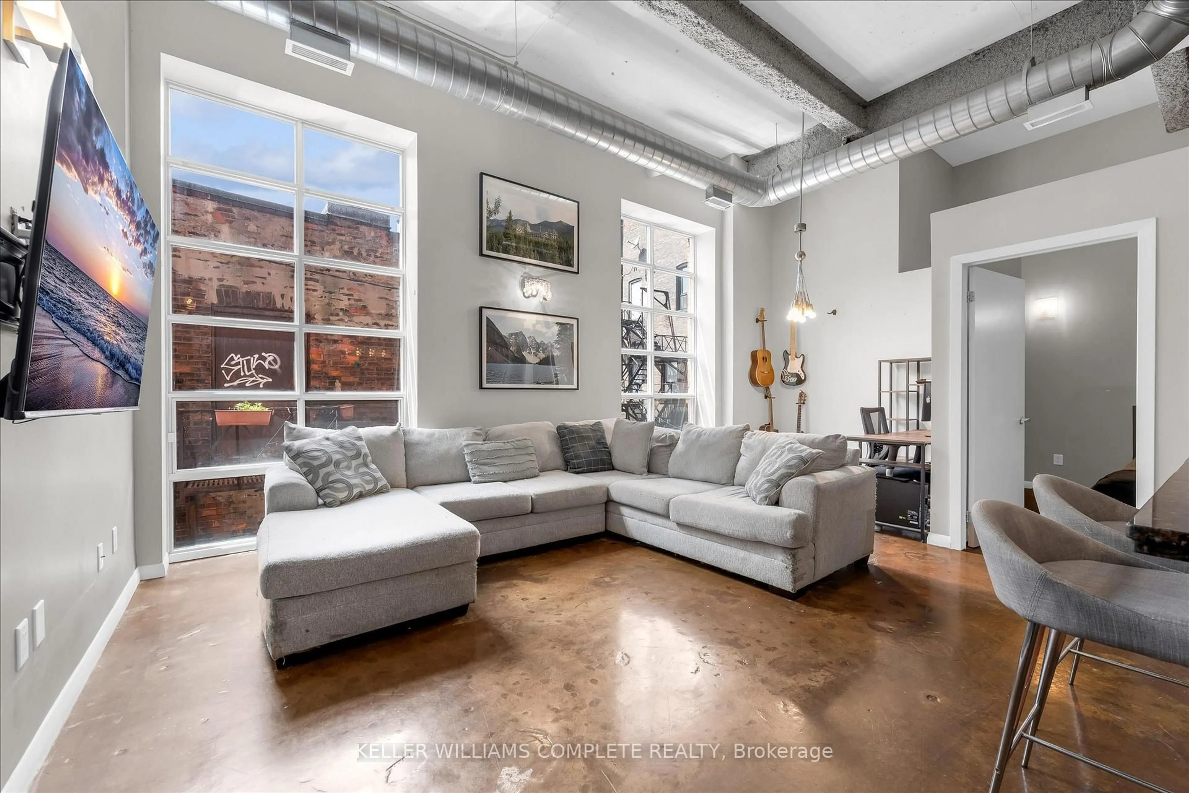 Living room with furniture, cement floor for 11 Rebecca St #208, Hamilton Ontario L8R 3H7
