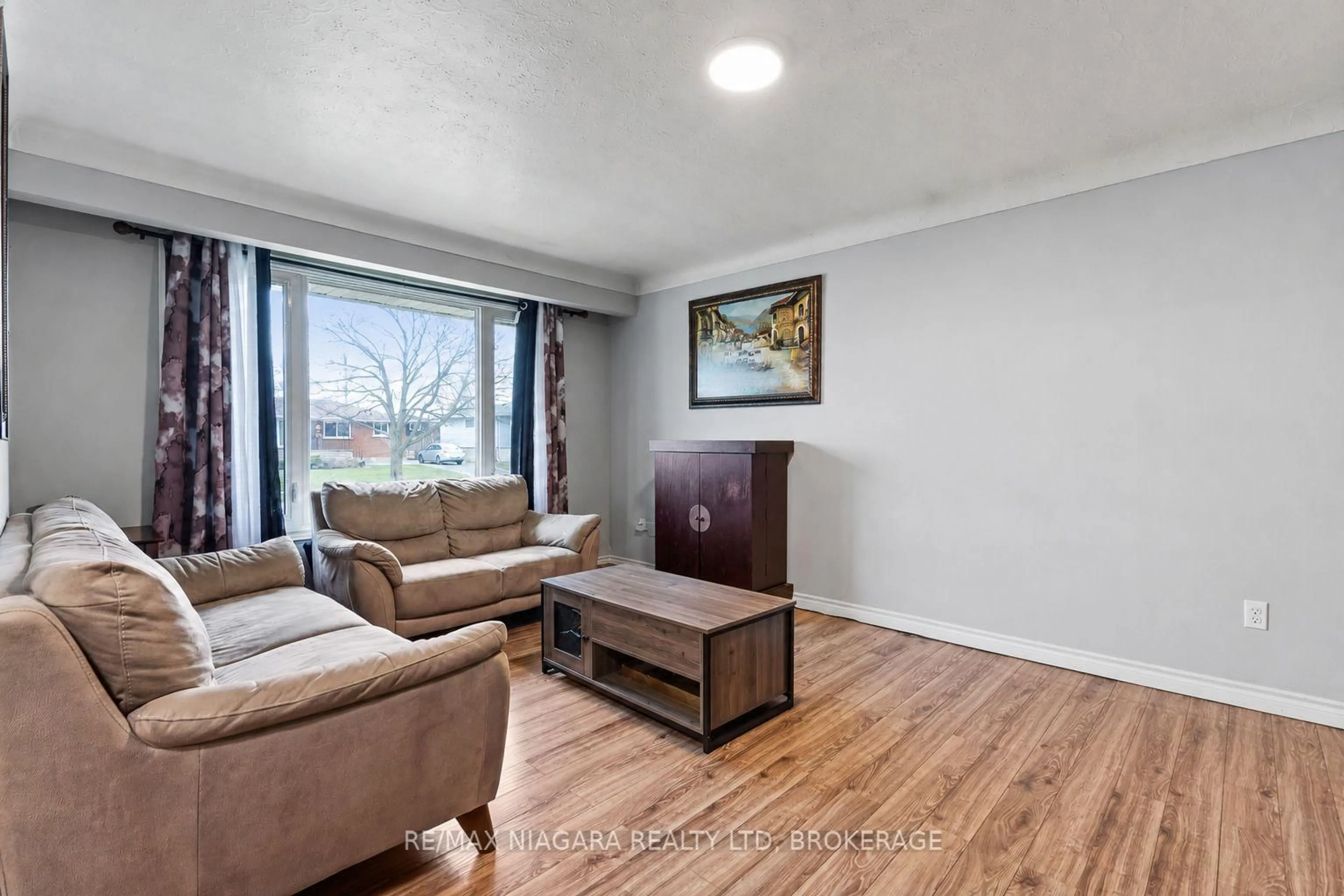 Living room with furniture, wood/laminate floor for 204 Hildred St, Welland Ontario L3B 1N1
