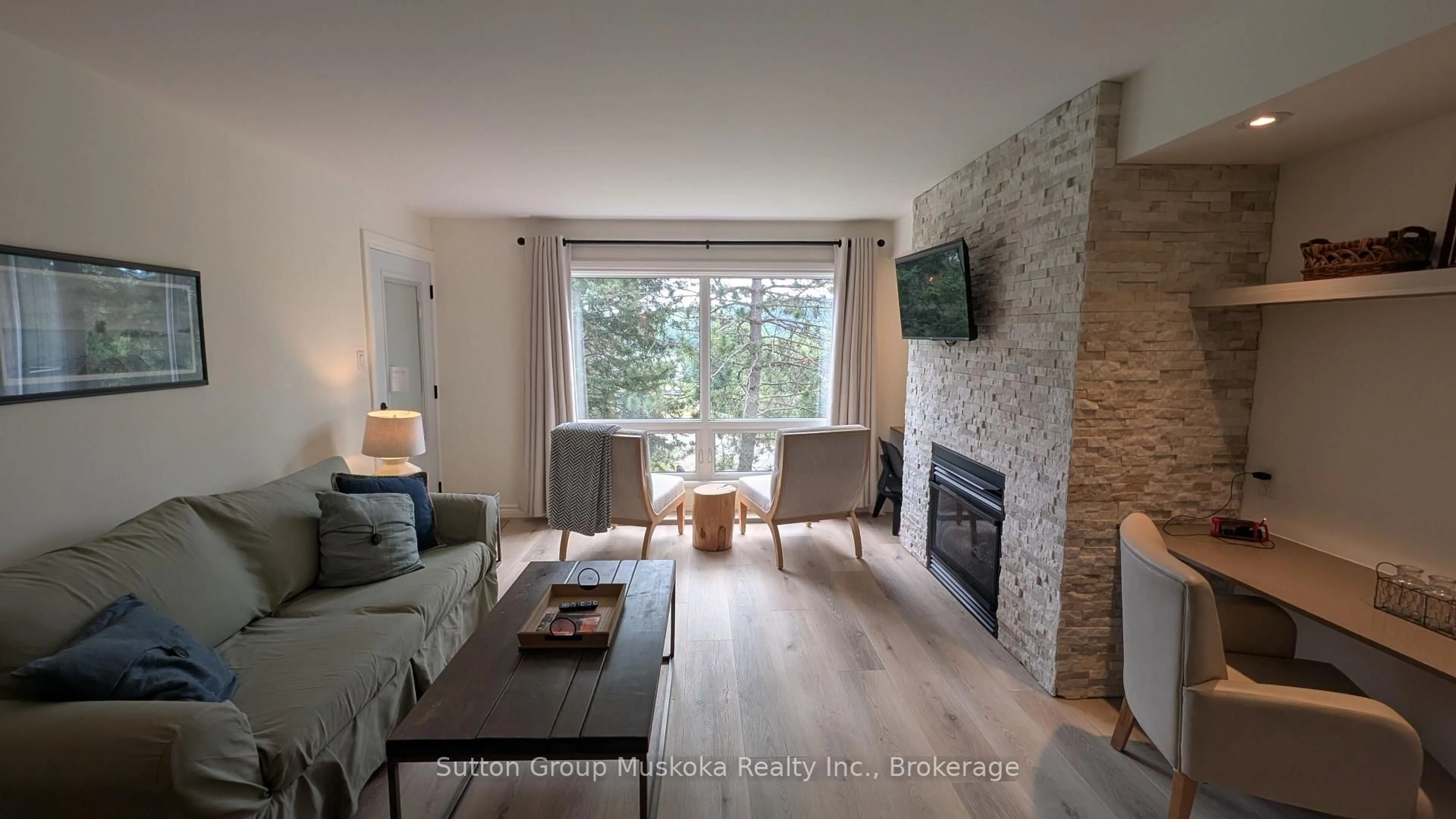 Living room with furniture, wood/laminate floor for 52-205 Deerhurst Dr, Huntsville Ontario P1H 2E8