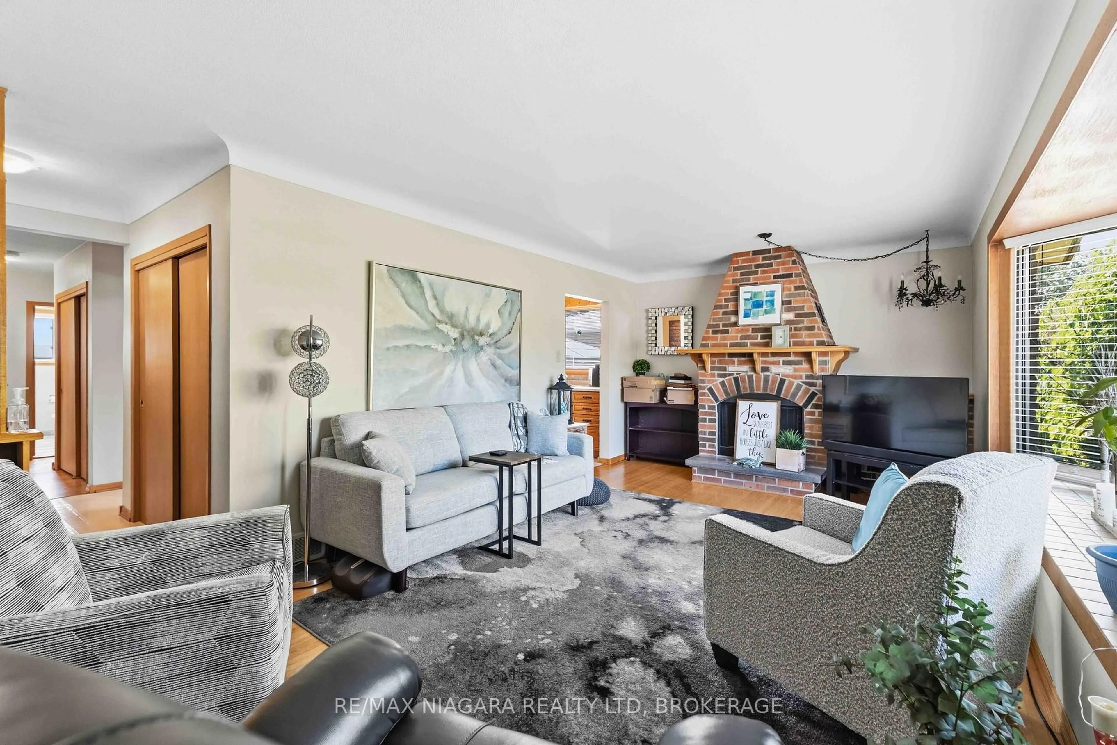 Living room with furniture, wood/laminate floor for 8689 Furlong Ave, Niagara Falls Ontario L2G 6W9