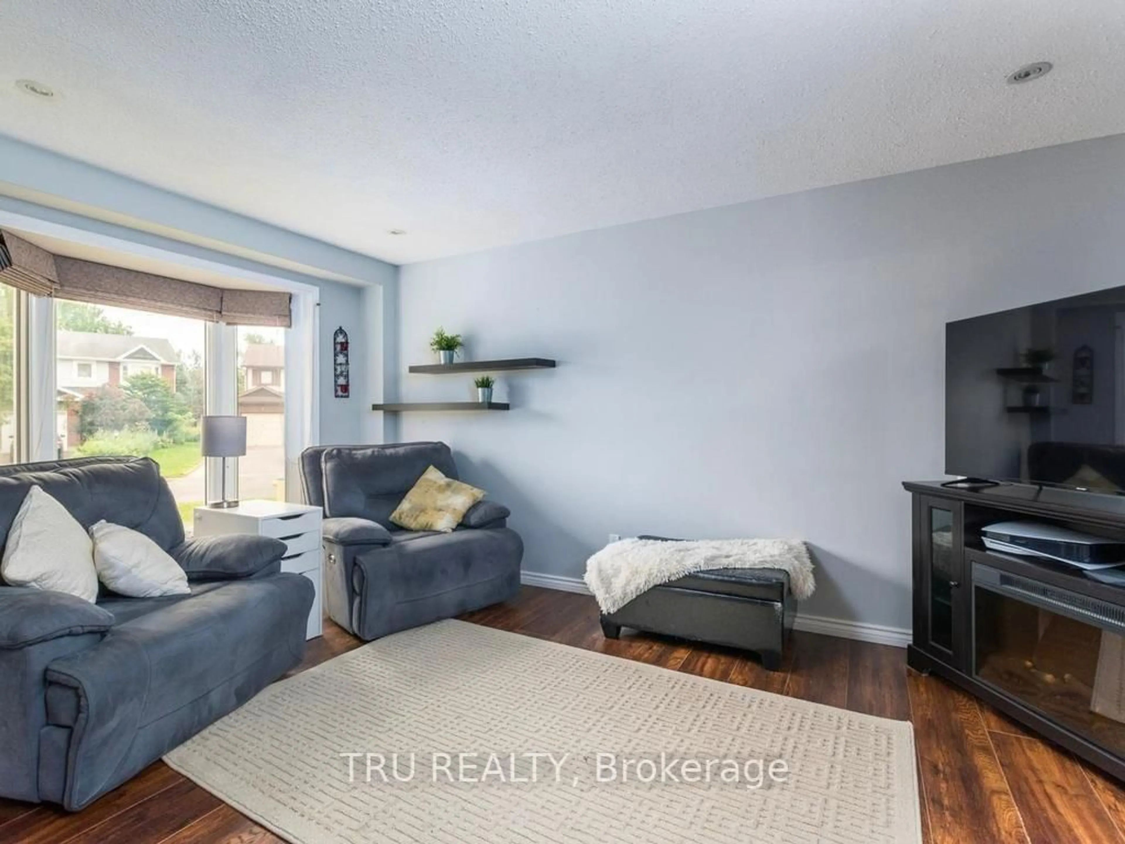 Living room with furniture, wood/laminate floor for 24 Soho Cres, Ottawa Ontario K2J 2W1