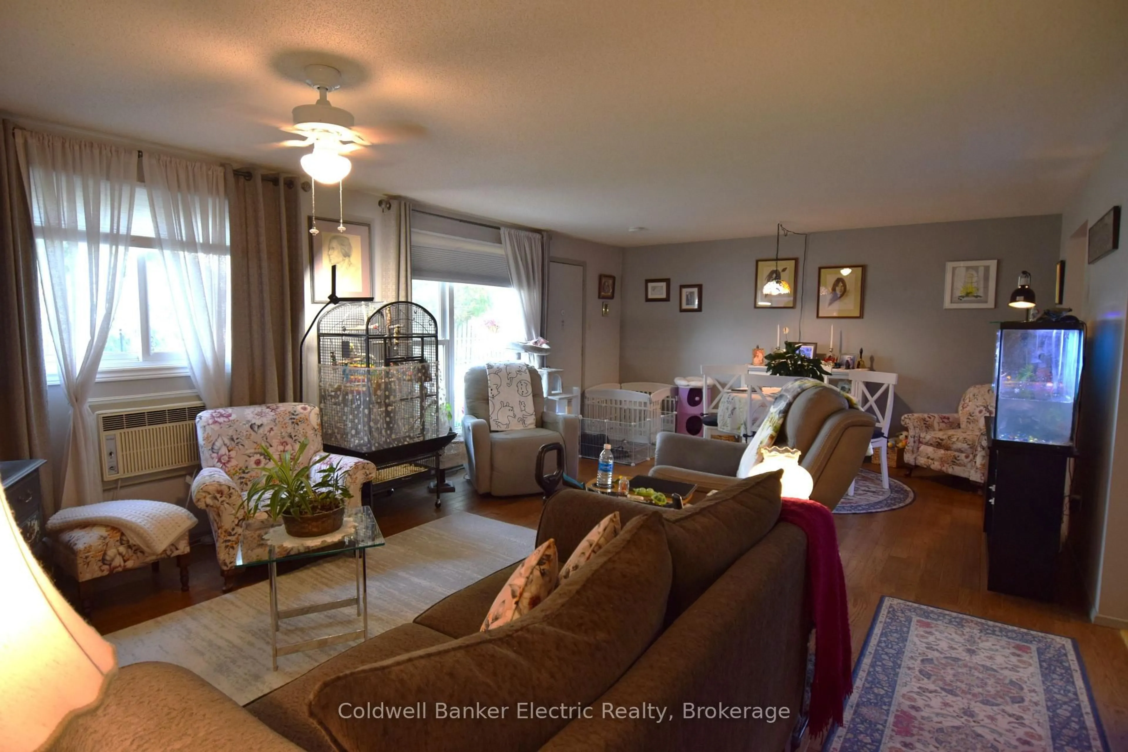 Living room with furniture, wood/laminate floor for 2418 Mountland Dr #104, Peterborough Ontario K9K 2E2