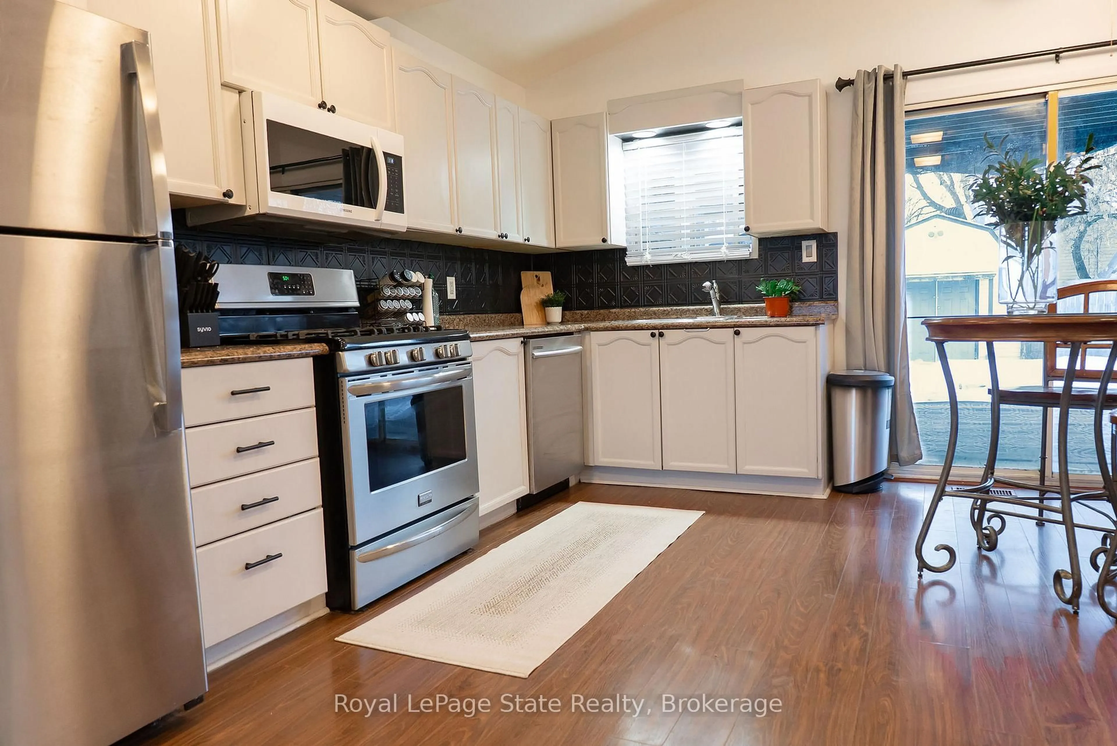 Open concept kitchen, wood/laminate floor for 717 Knox Ave, Hamilton Ontario L8H 6K7