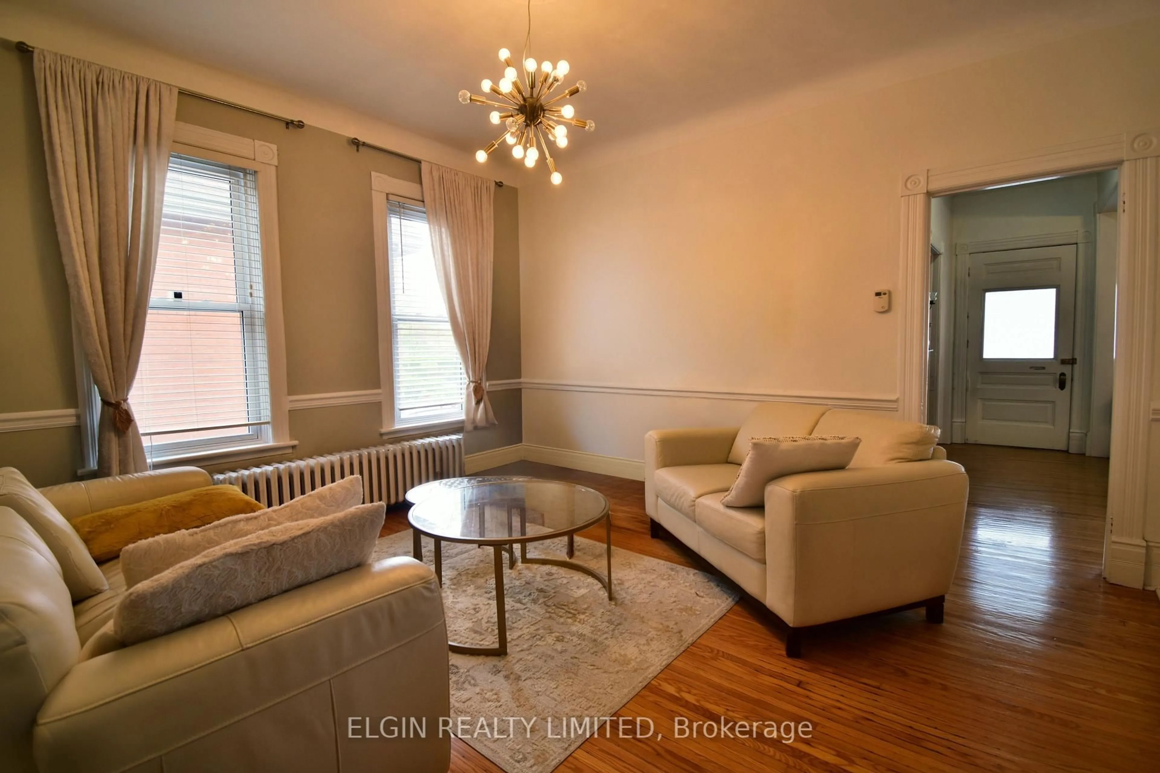 Living room with furniture, wood/laminate floor for 17 Prince Albert St, St. Thomas Ontario N5R 1Z7