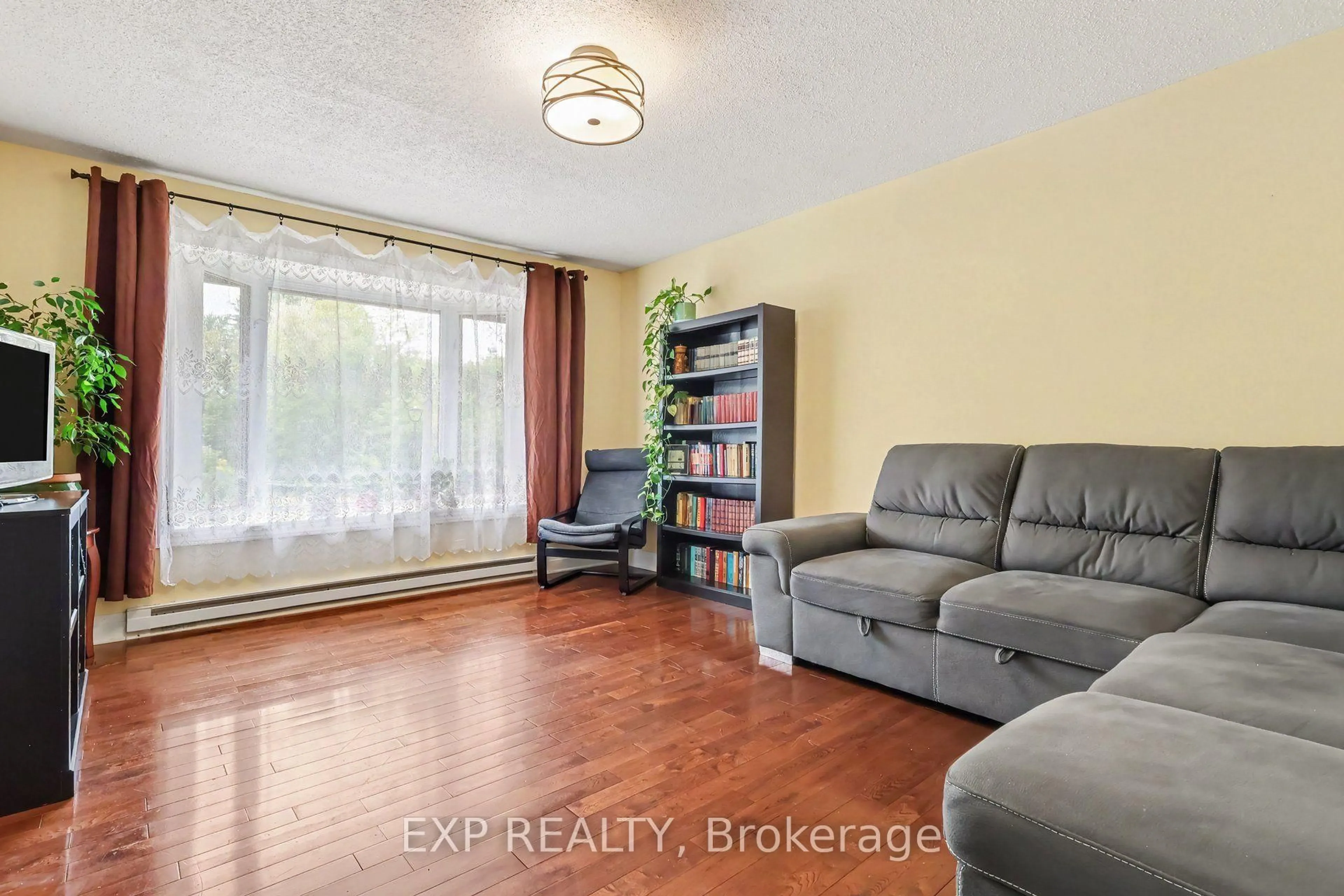 Living room with furniture, wood/laminate floor for 1594 Fortier St #26, Ottawa Ontario K1T 1T7