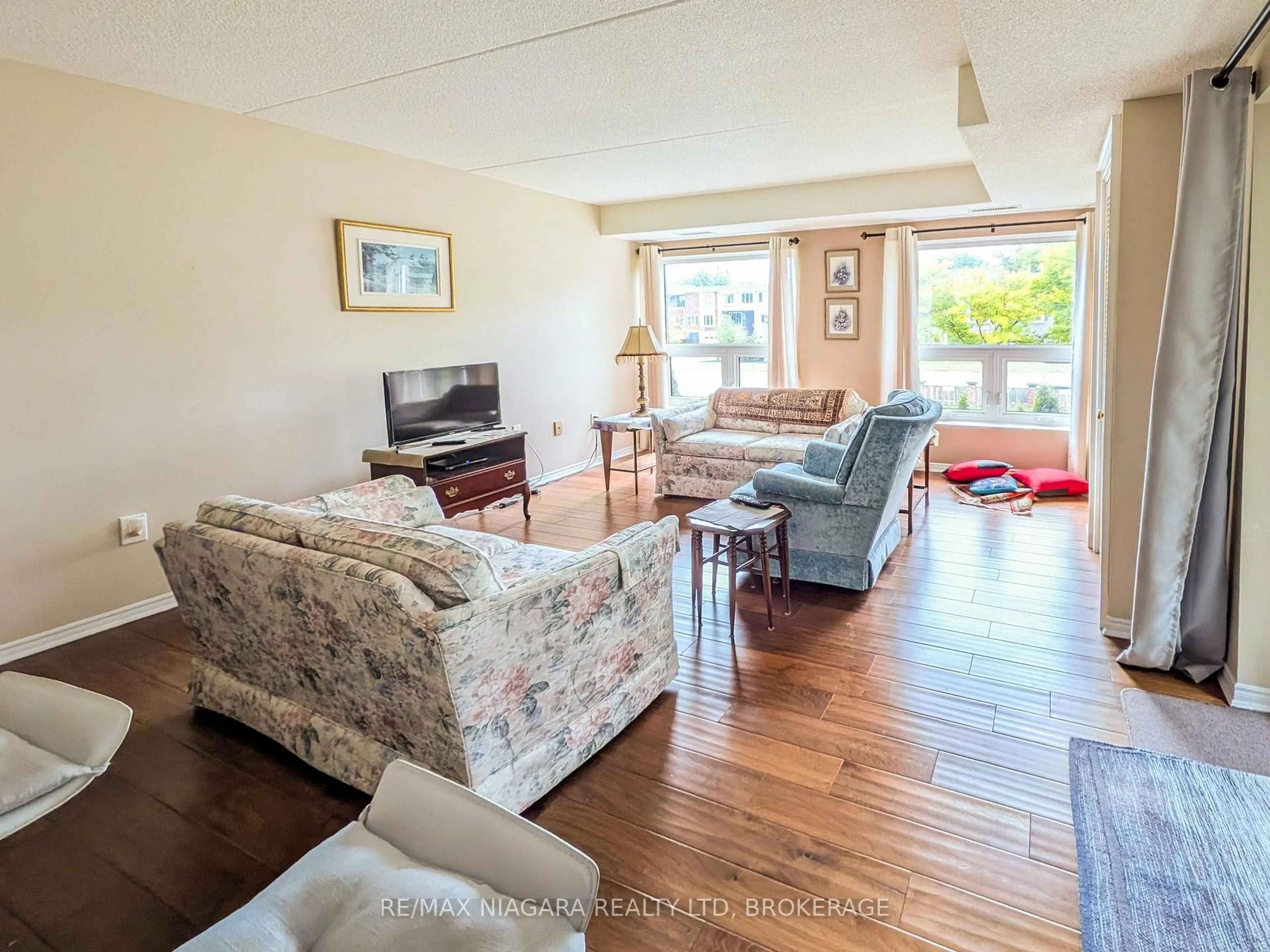 Living room with furniture, wood/laminate floor for 6704 Thorold Stone Rd #203, Niagara Falls Ontario L2J 1B3