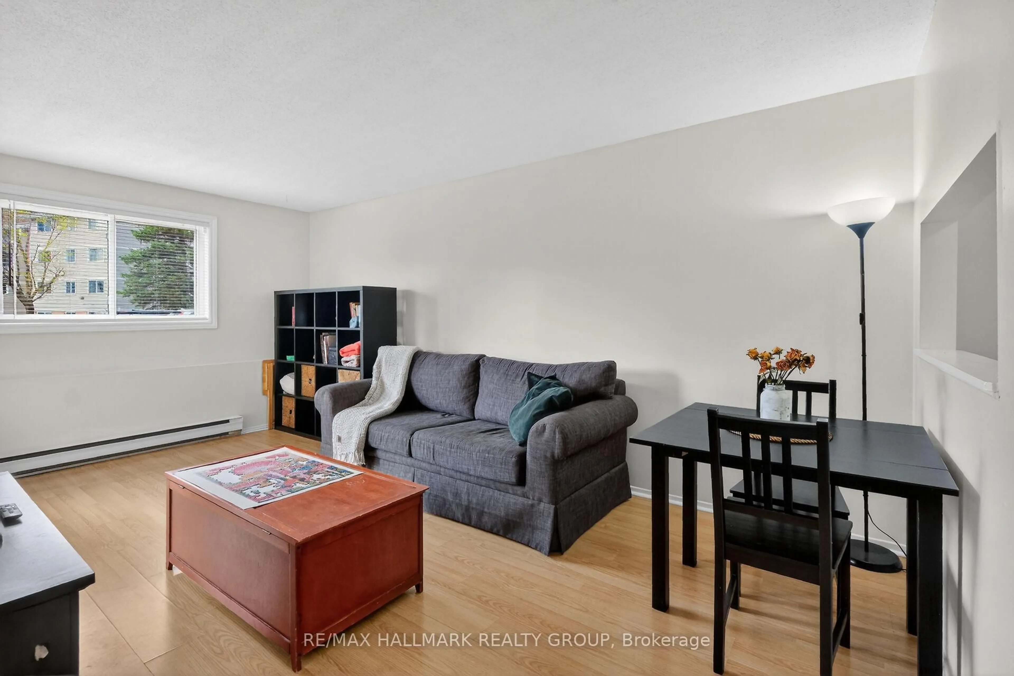 Living room with furniture, wood/laminate floor for 280 Brittany Dr #102, Ottawa Ontario K1K 4M4