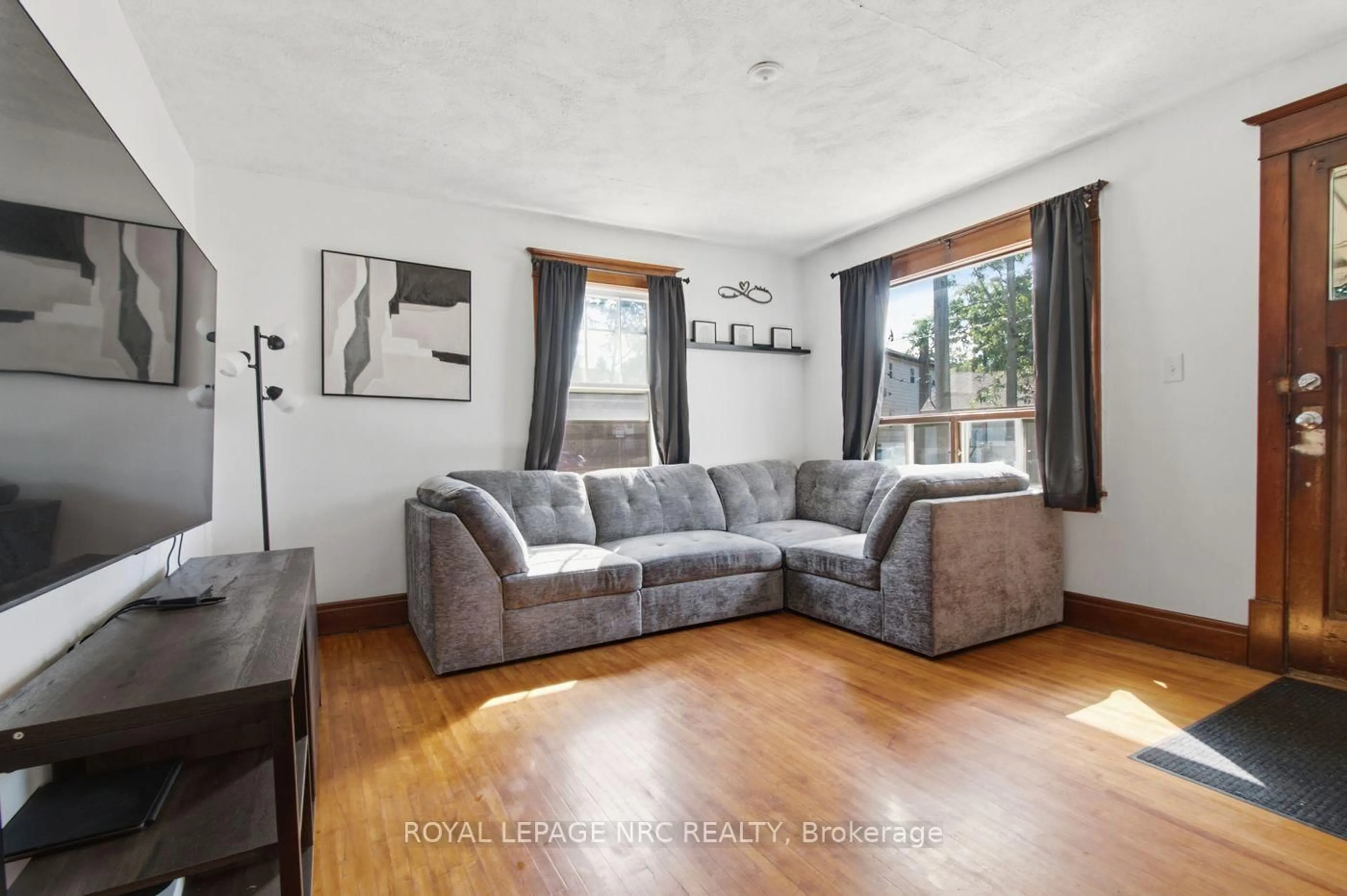 Living room with furniture, wood/laminate floor for 79 Carlton St, St. Catharines Ontario L2R 1R1