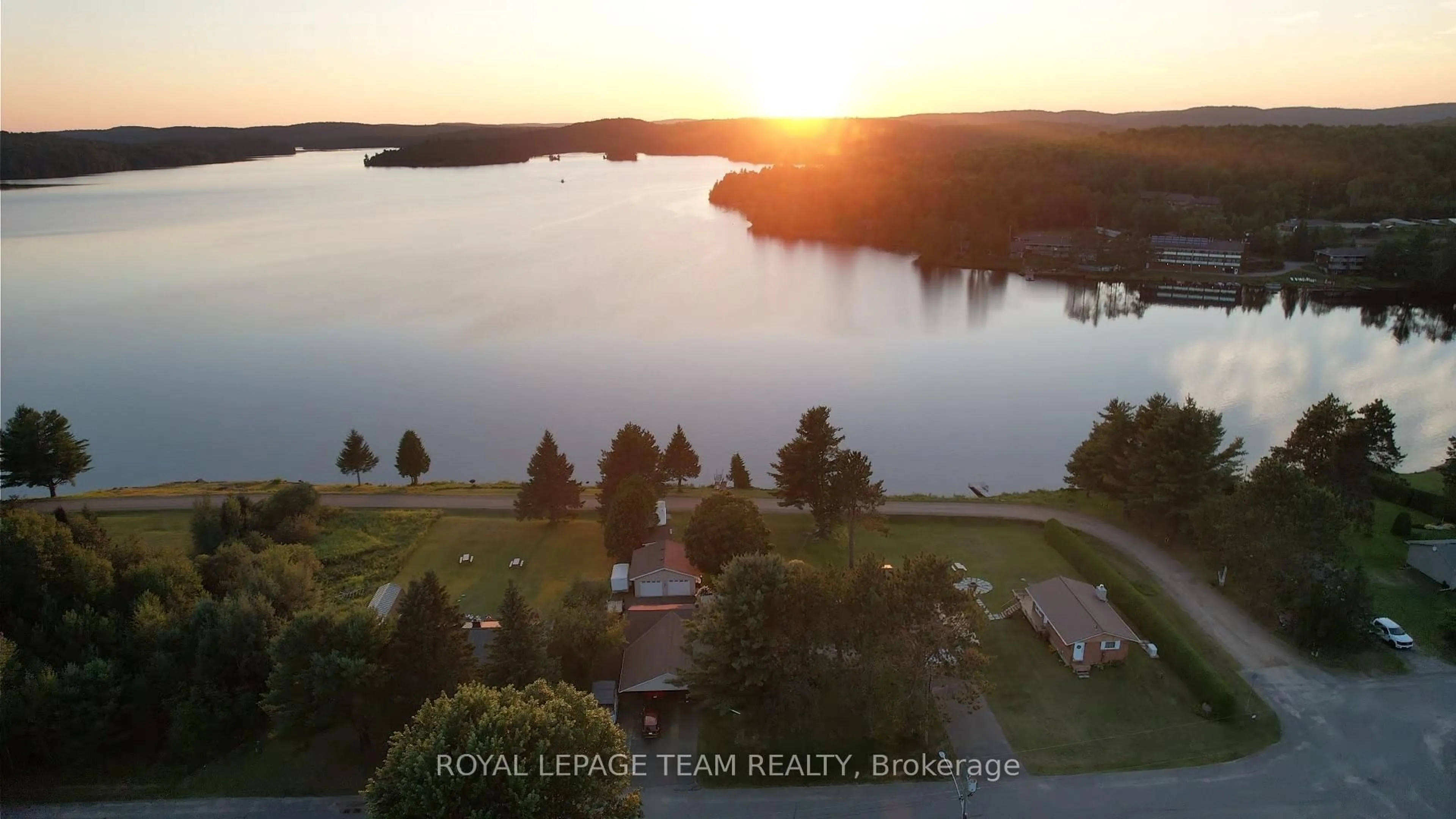 A pic from outside/outdoor area/front of a property/back of a property/a pic from drone, water/lake/river/ocean view for 76 Lake St, South Algonquin Ontario K0J 2M0