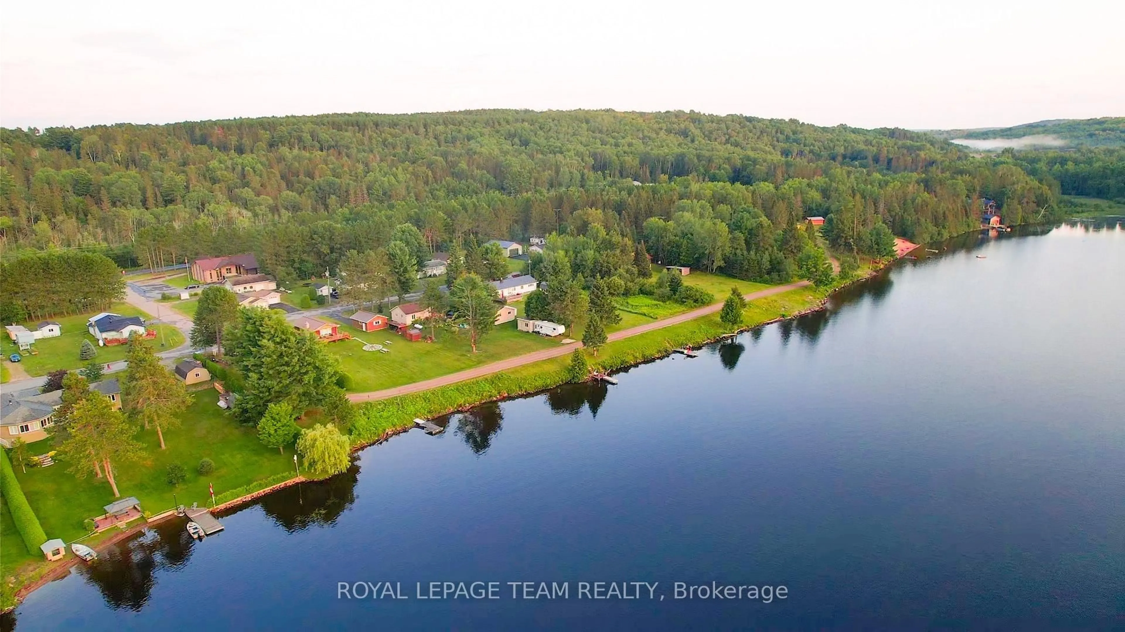 A pic from outside/outdoor area/front of a property/back of a property/a pic from drone, water/lake/river/ocean view for 76 Lake St, South Algonquin Ontario K0J 2M0