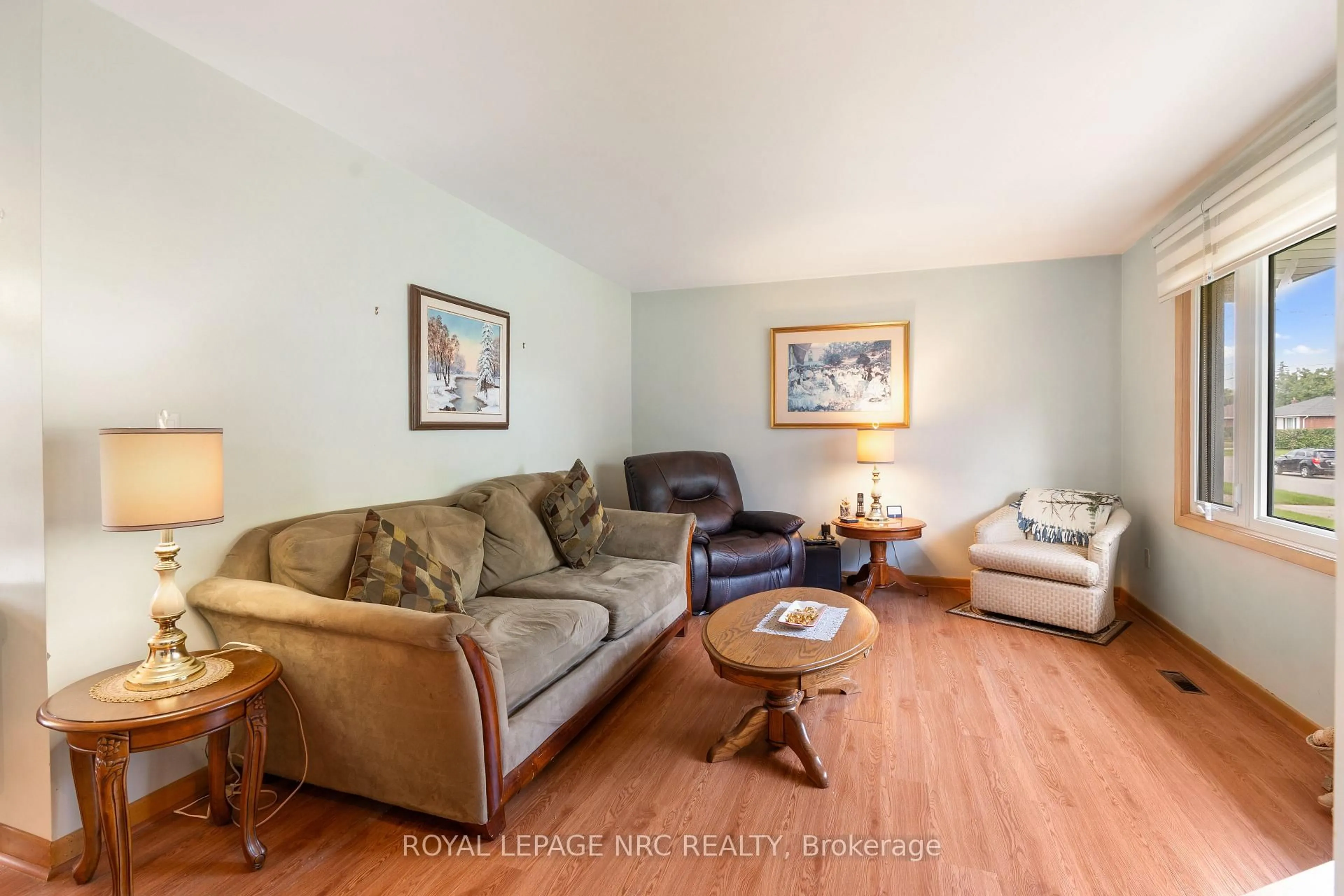 Living room with furniture, wood/laminate floor for 7427 Merritt Ave, Niagara Falls Ontario L2G 5C3