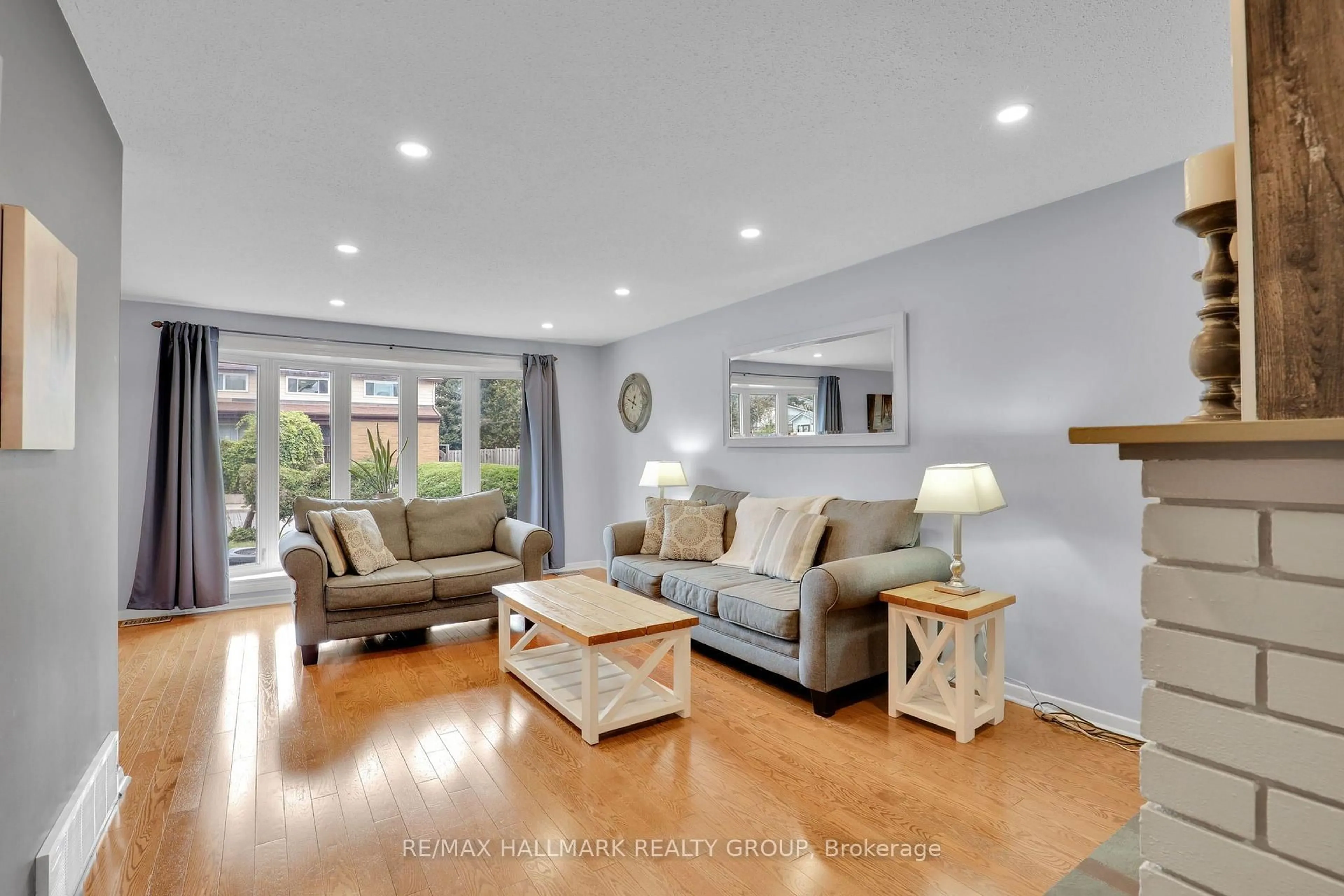Living room with furniture, wood/laminate floor for 90 Chesterton Dr, Ottawa Ontario K2E 5T6