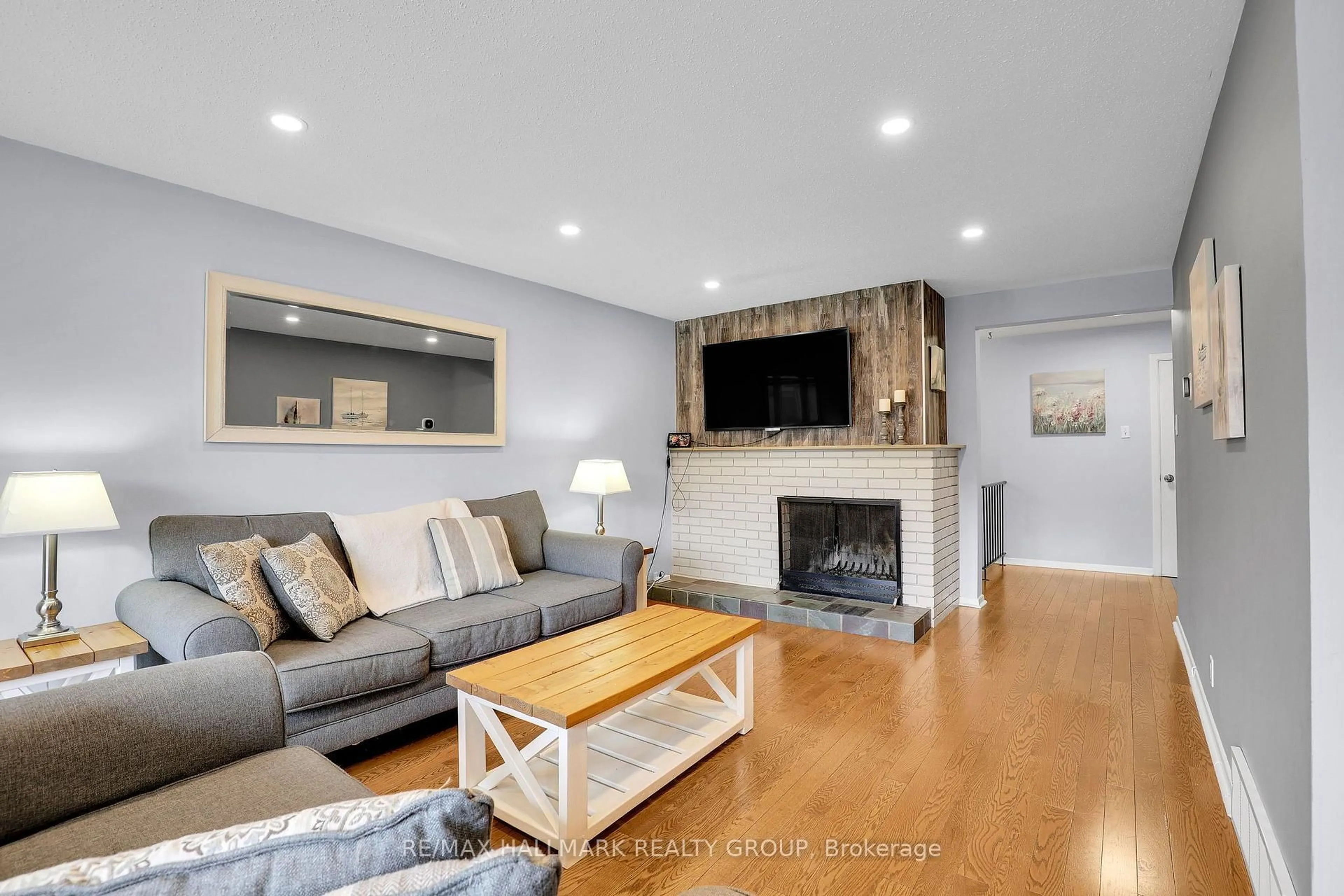 Living room with furniture, wood/laminate floor for 90 Chesterton Dr, Ottawa Ontario K2E 5T6