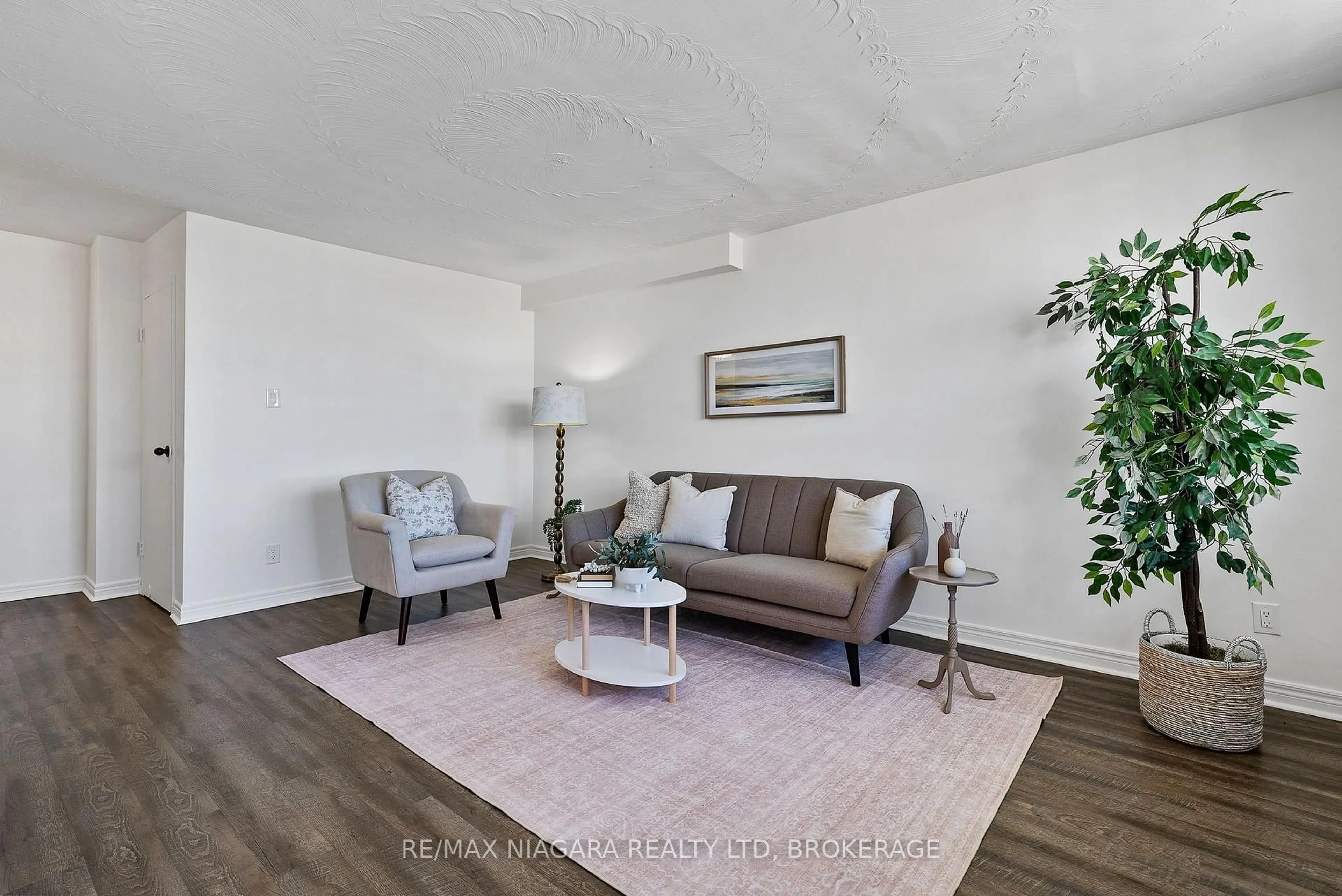 Living room with furniture, wood/laminate floor for 359 Geneva St #1002, St. Catharines Ontario L2N 2G5