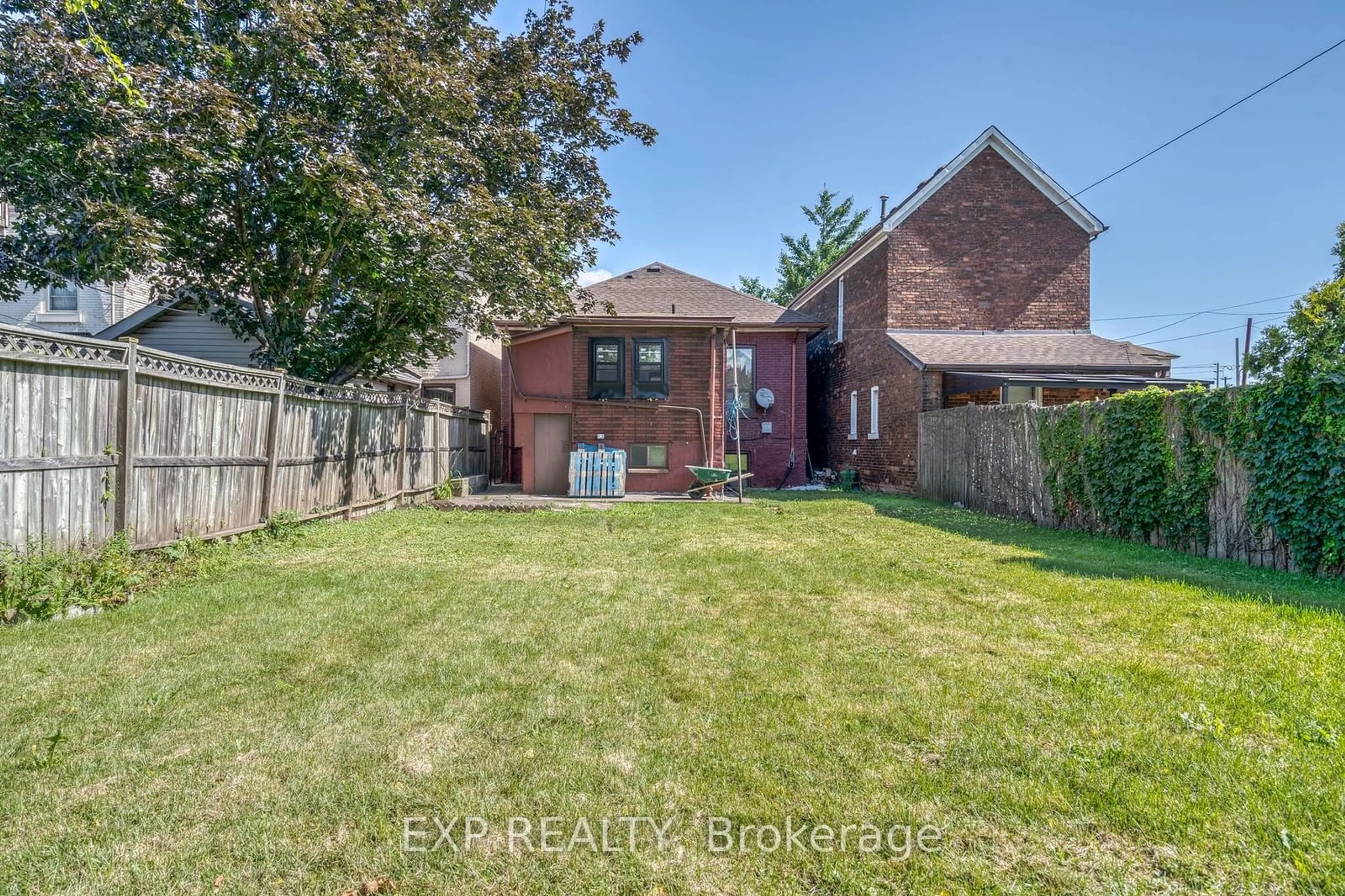 Frontside or backside of a home, the fenced backyard for 81 Colbourne St, Hamilton Ontario L8R 2G6