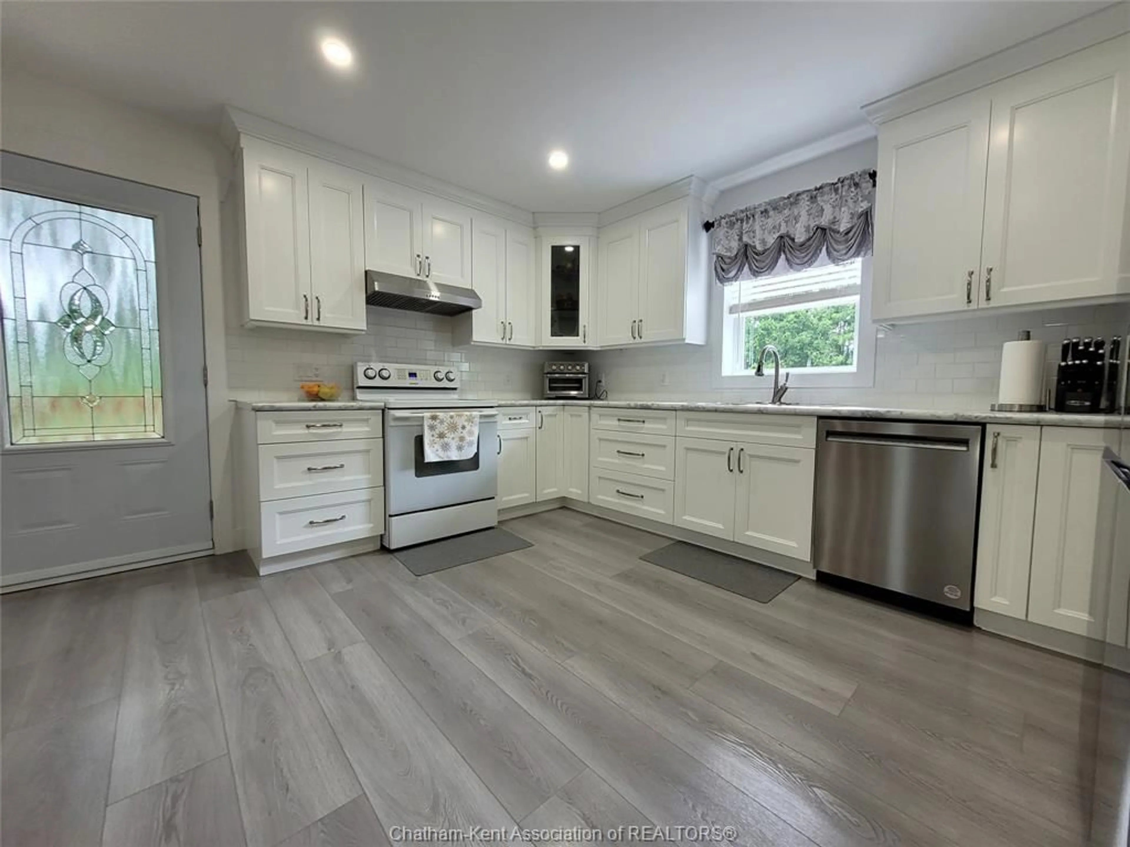 Open concept kitchen, wood/laminate floor for 13355 JANE St, Thamesville Ontario N0P 2K0